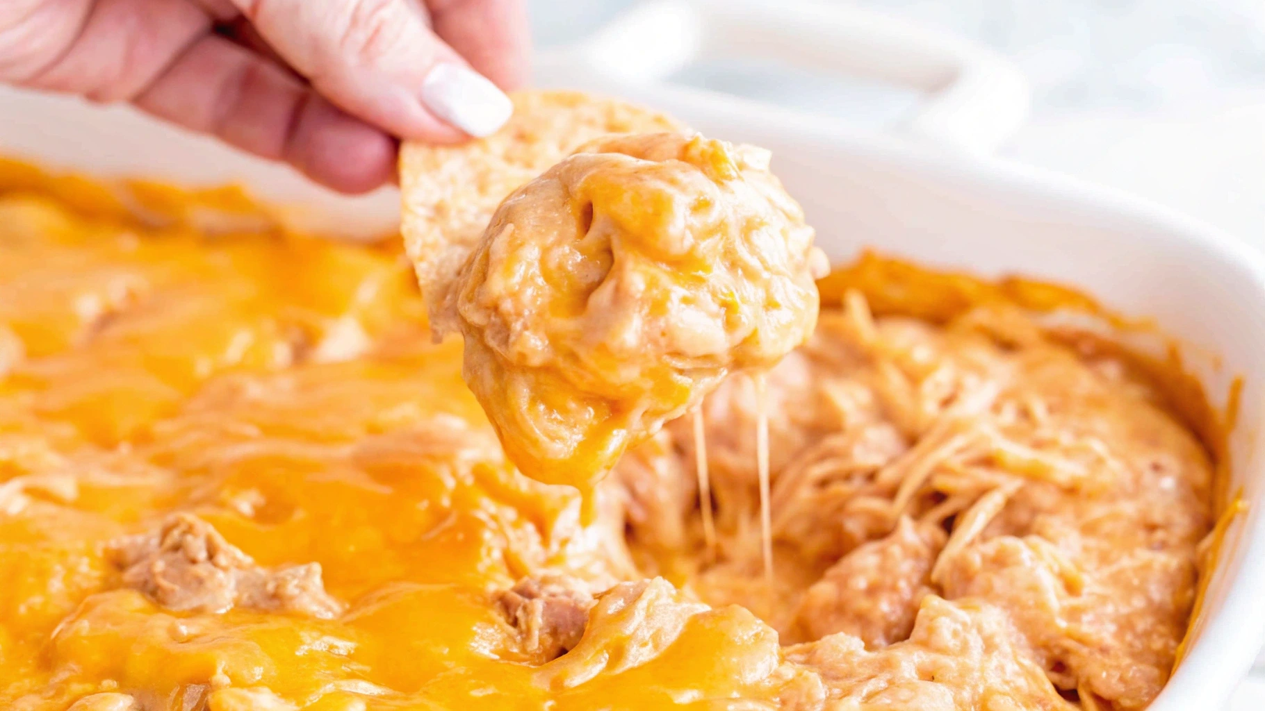 A creamy and spicy Buffalo Chicken Dip made with canned chicken, topped with melted cheese, and served with tortilla chips.